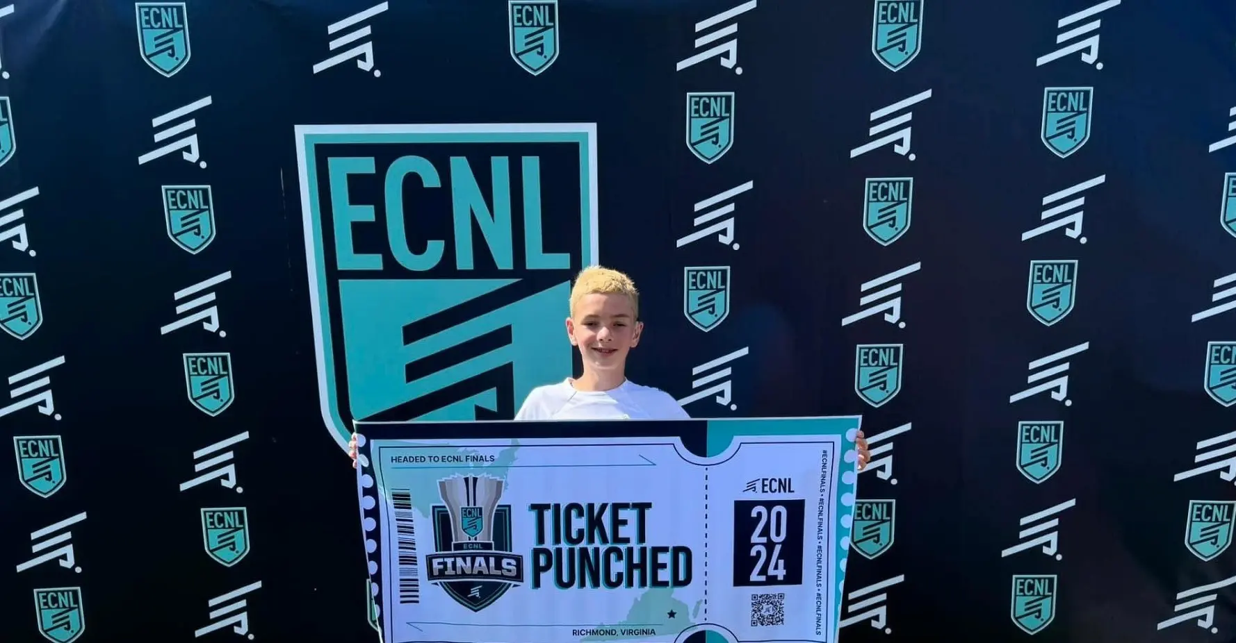 Daylen Hammon holding oversized ECNL Finals Ticket Punched sign in front of ECNL step-and-repeat backdrop, Del Mar CA June 2024