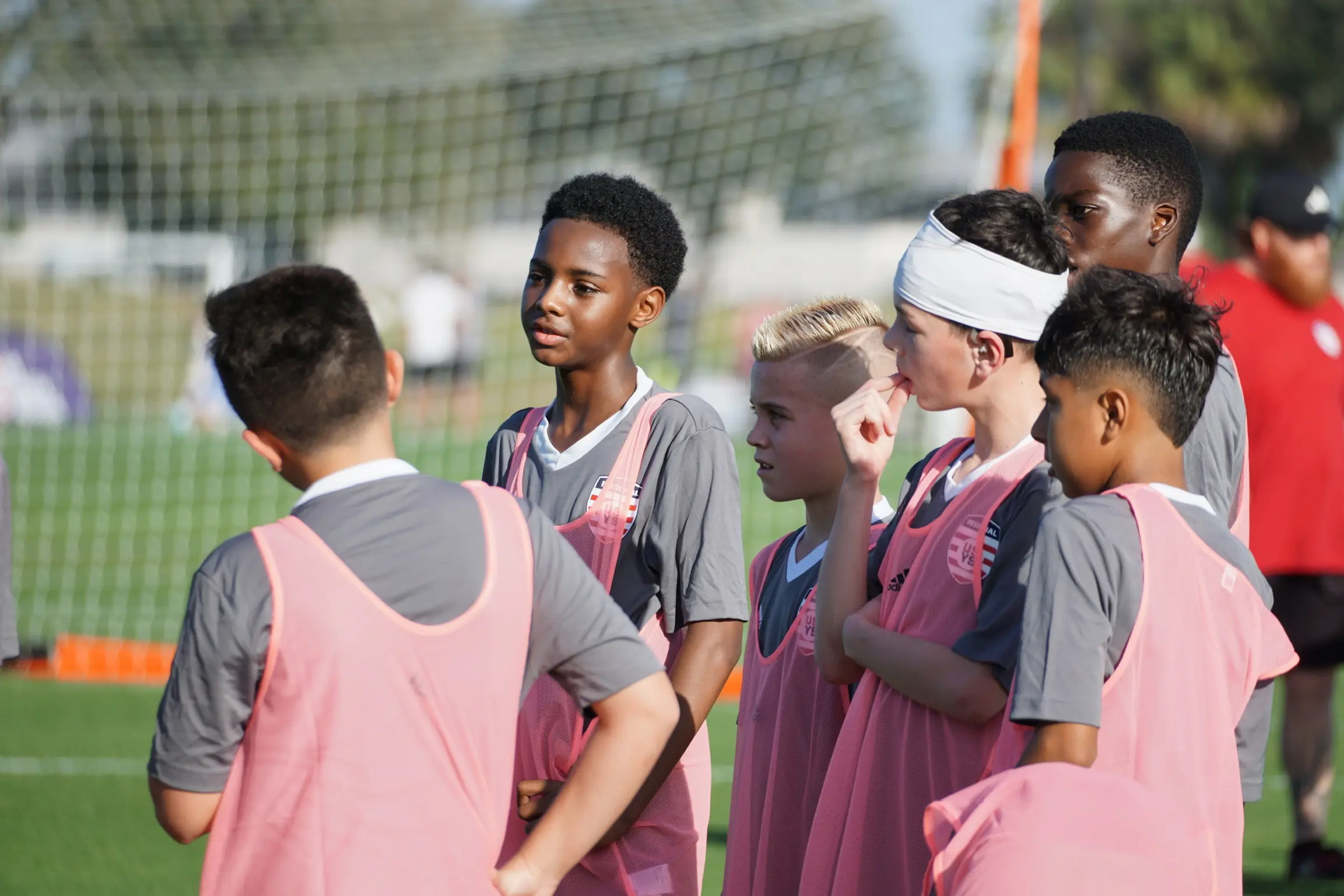 Daylen Hammon #5 with white headband in pink ODP training bib listening to coaches at Easter International Cup