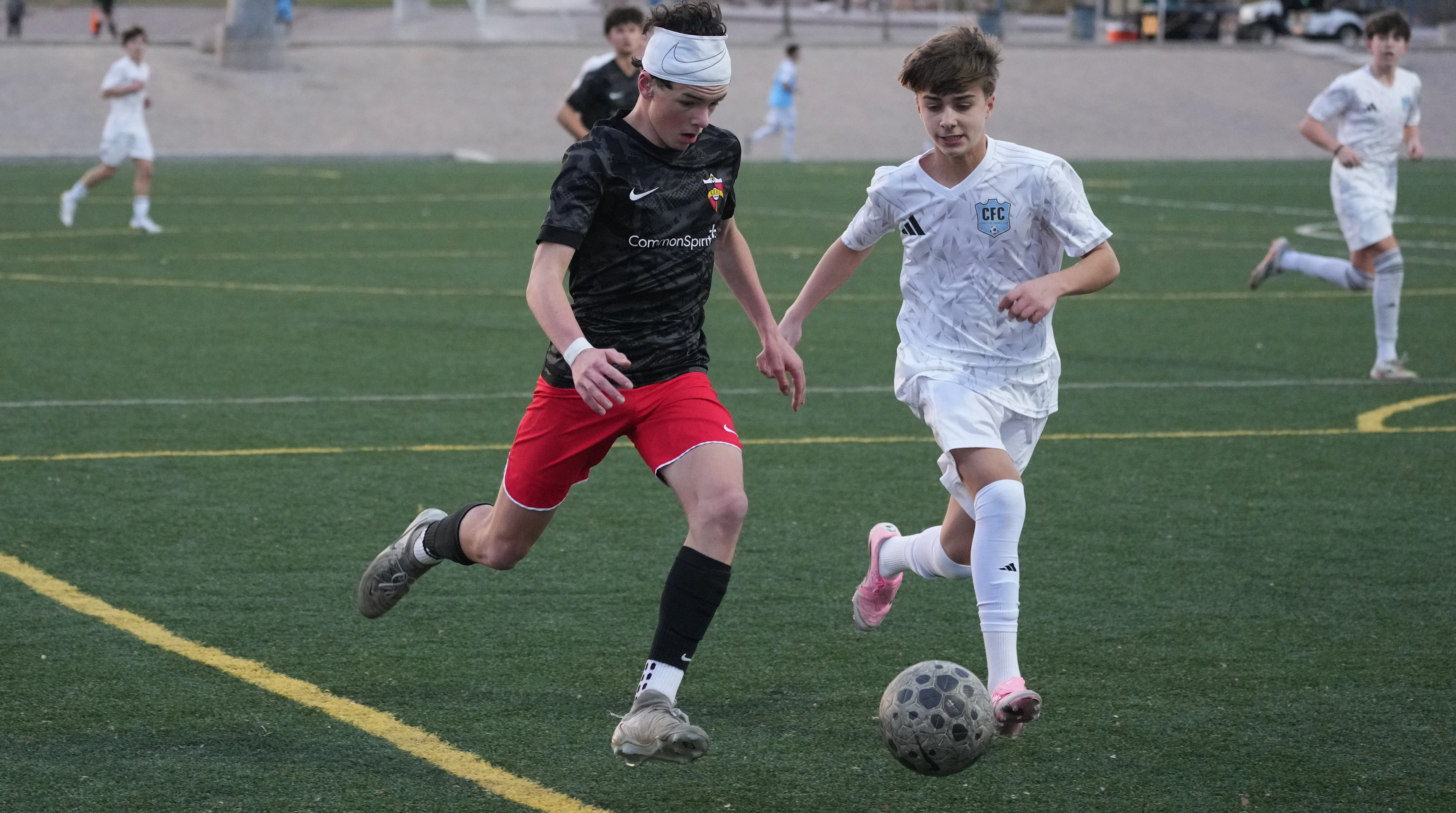 Daylen Hammon in black Real Colorado Datec kit battling for the ball vs CFC player in white