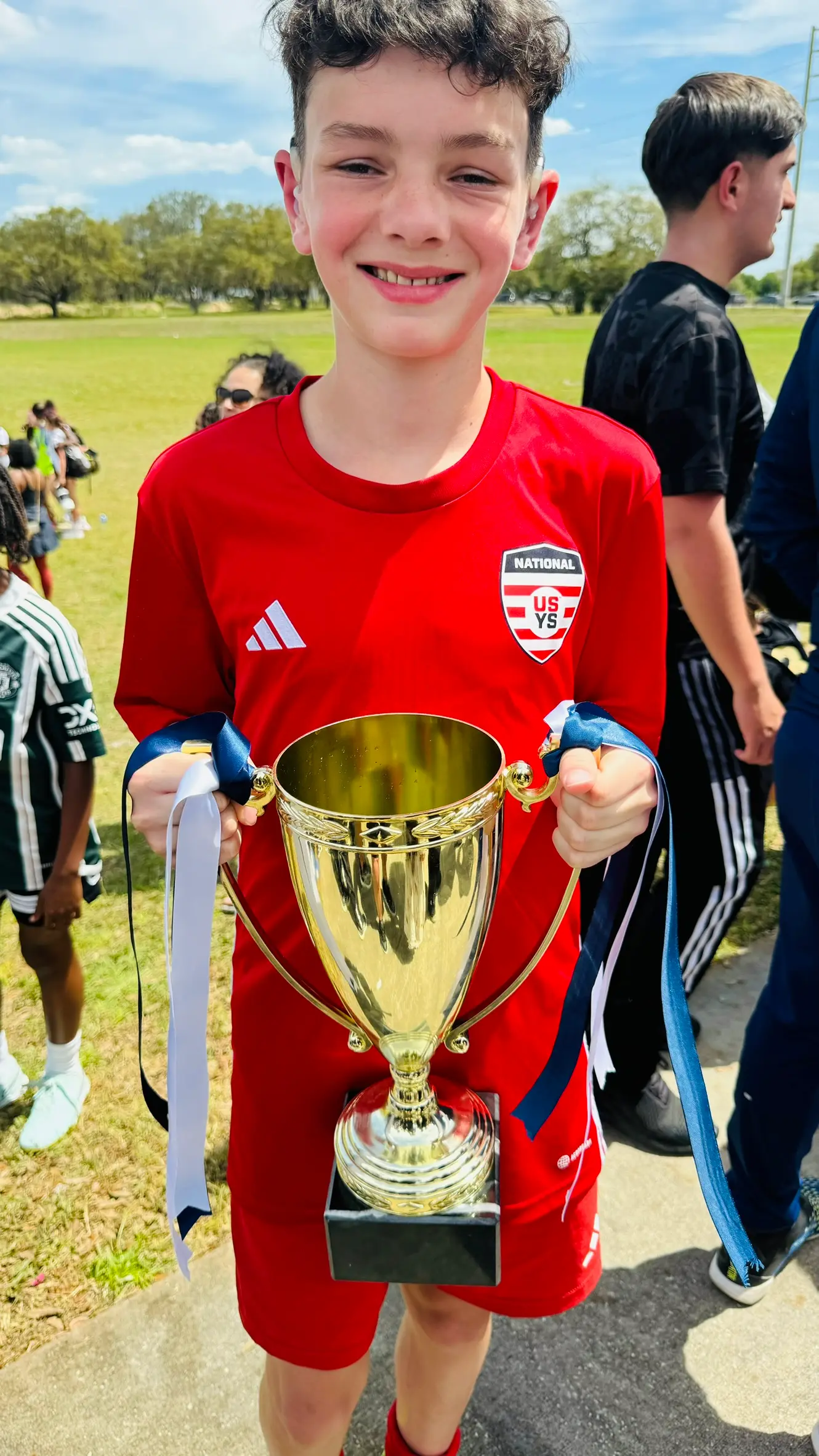 Daylen Hammon in red ODP National kit holding gold Easter International Cup trophy in Orlando