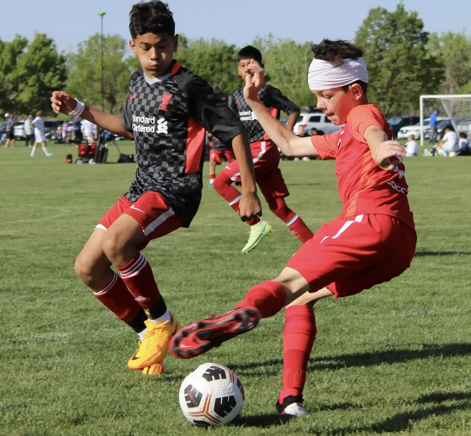 Daylen Hammon in red Real Colorado kit shooting vs Liverpool FC kit player