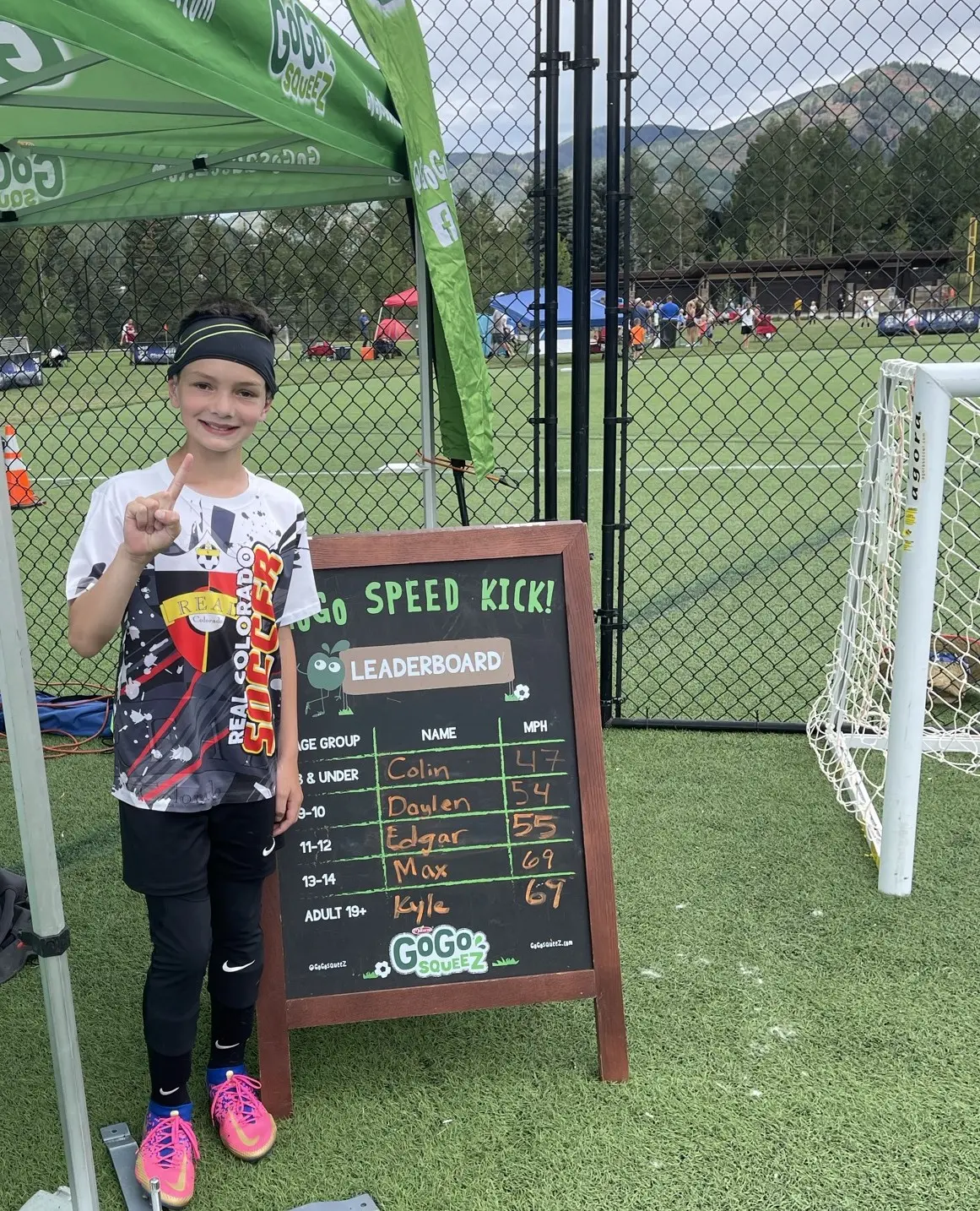 Daylen Hammon pointing to his name on GoGo Squeez Speed Kick leaderboard at 54 MPH