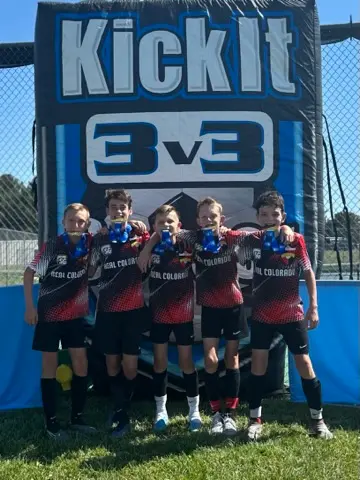 Daylen Hammon young with Kick It 3v3 blue medals in front of Kick It backdrop