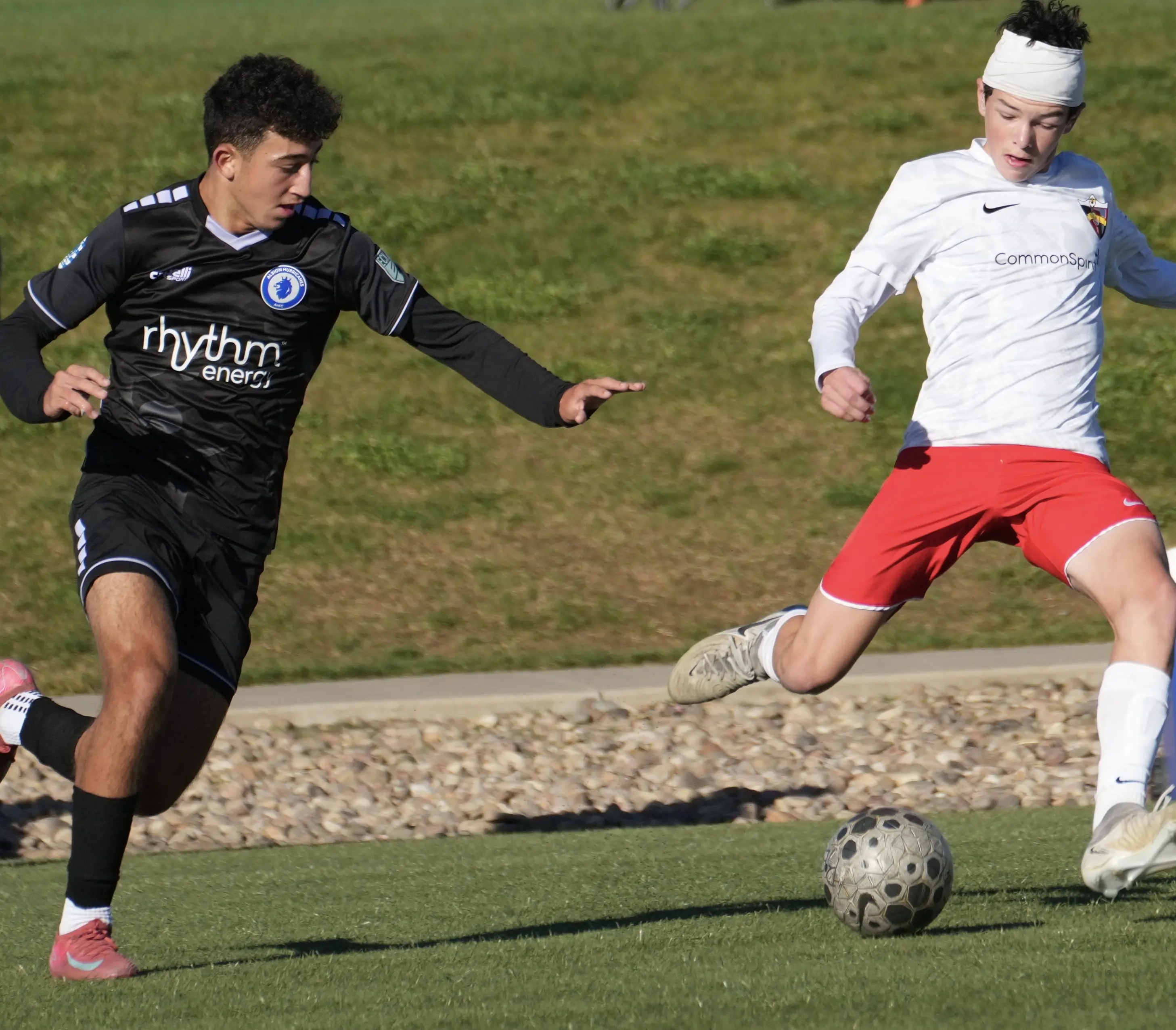 Daylen Hammon in white Real Colorado kit driving past Rhythm Energy defender