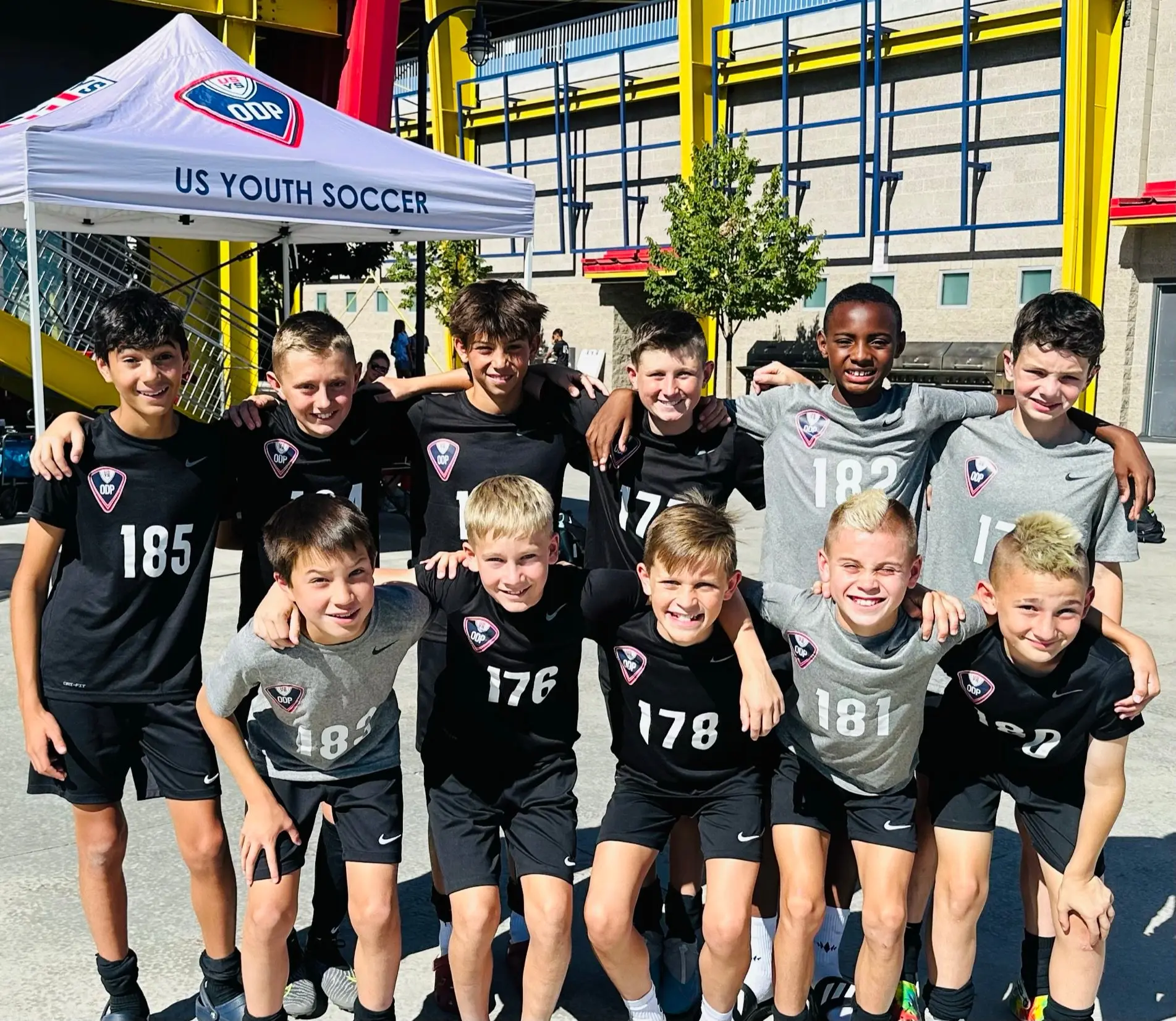 Real Colorado Academy team with gold medals in front of futsal goal indoors