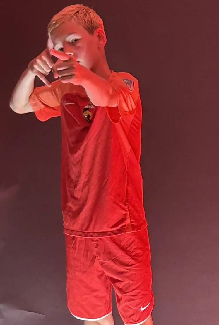 Daylen Hammon in red Real Colorado kit pointing at camera with dramatic red studio lighting
